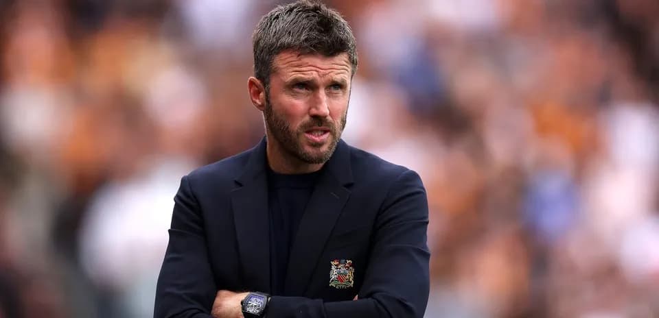 Manager observing match with arms crossed on sideline