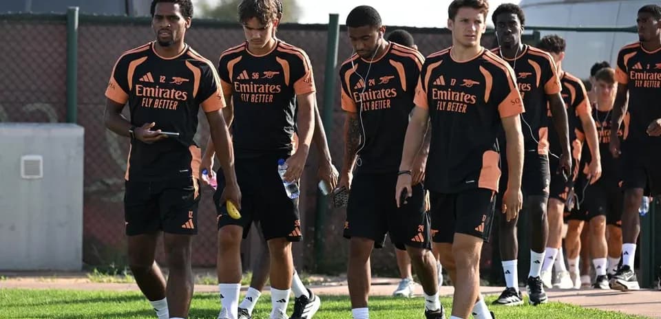 Arsenal players walking to training session on pitch