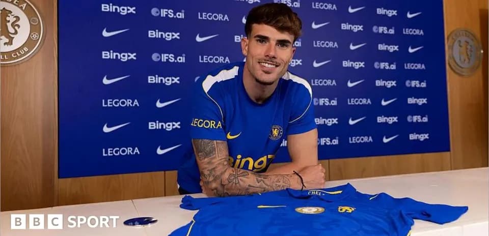 Player posing with Chelsea jersey at press event