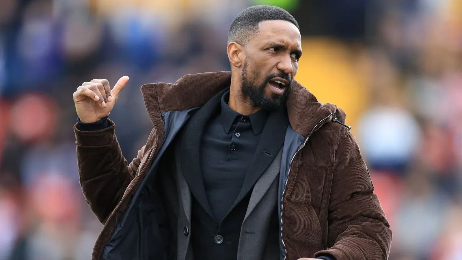 Coach gesturing during a football match on sidelines