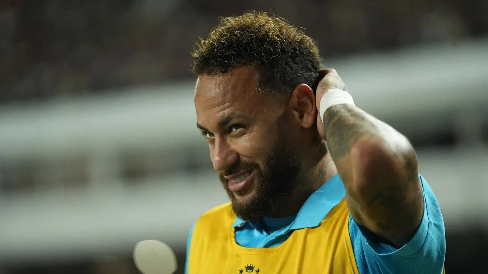 Neymar adjusting his hair on the sidelines