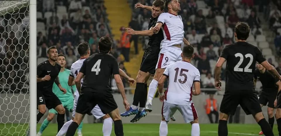 Players jumping for a header in football match