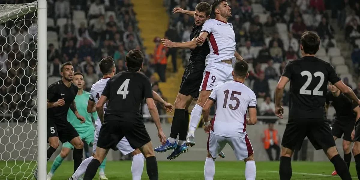 Players jumping for a header in football match