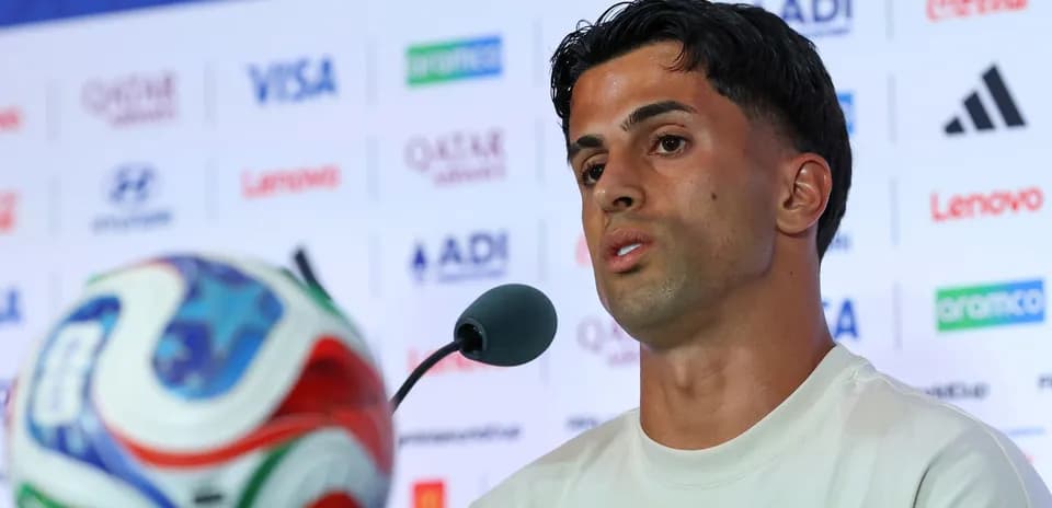 Player speaking at press conference with soccer ball