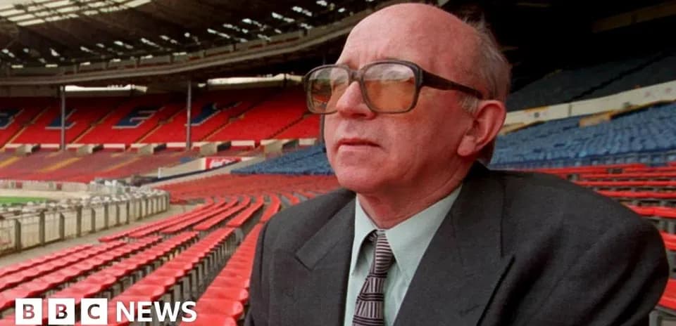 Man sitting in empty stadium seats, looking ahead