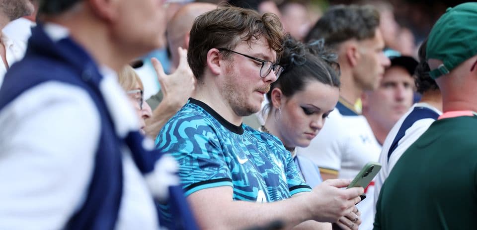Fans watching the match, some using smartphones