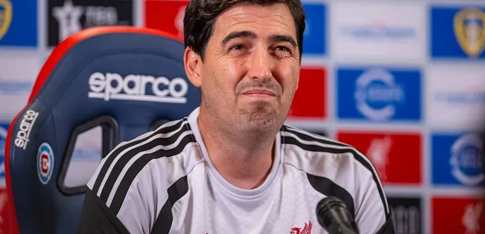 Manager at press conference with team logo backdrop