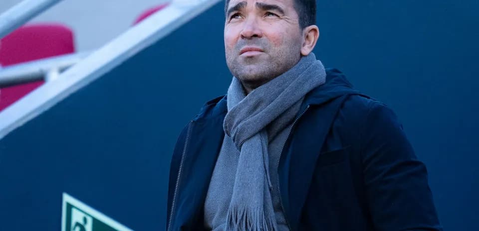 Man looking upwards, wearing a scarf and jacket