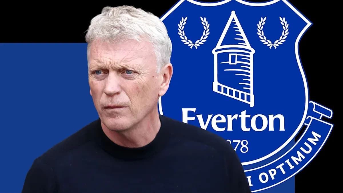 Manager standing in front of Everton club logo