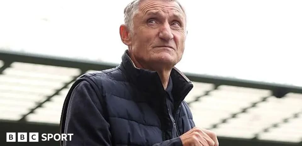 Man holding a bottle at a sports venue