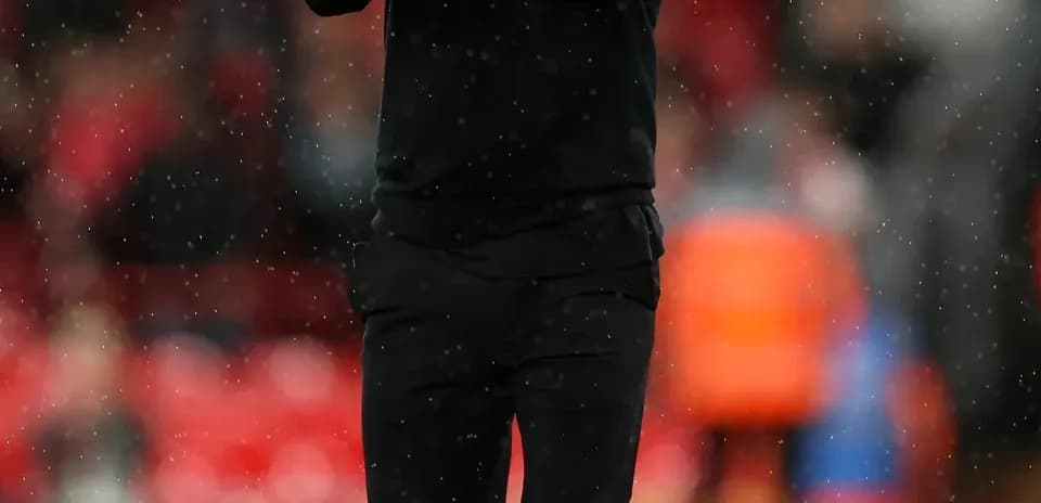 Coach applauding while walking on the pitch