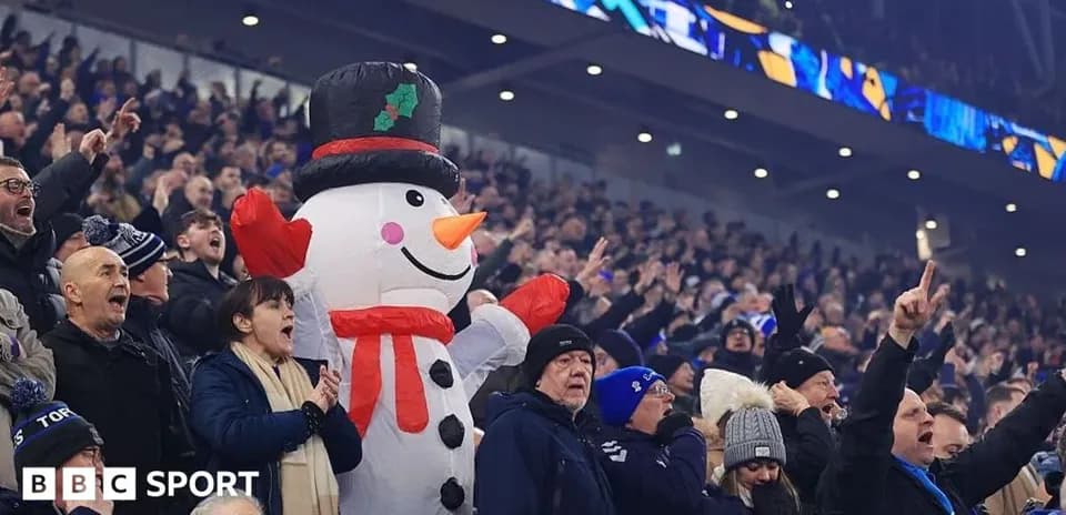 Fans celebrating with a large snowman mascot