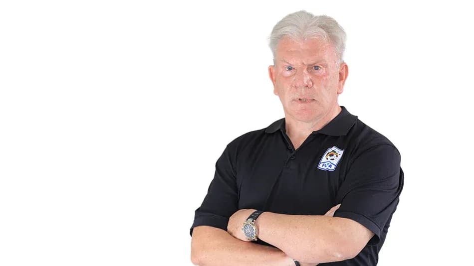 Coach posing with arms crossed in black polo