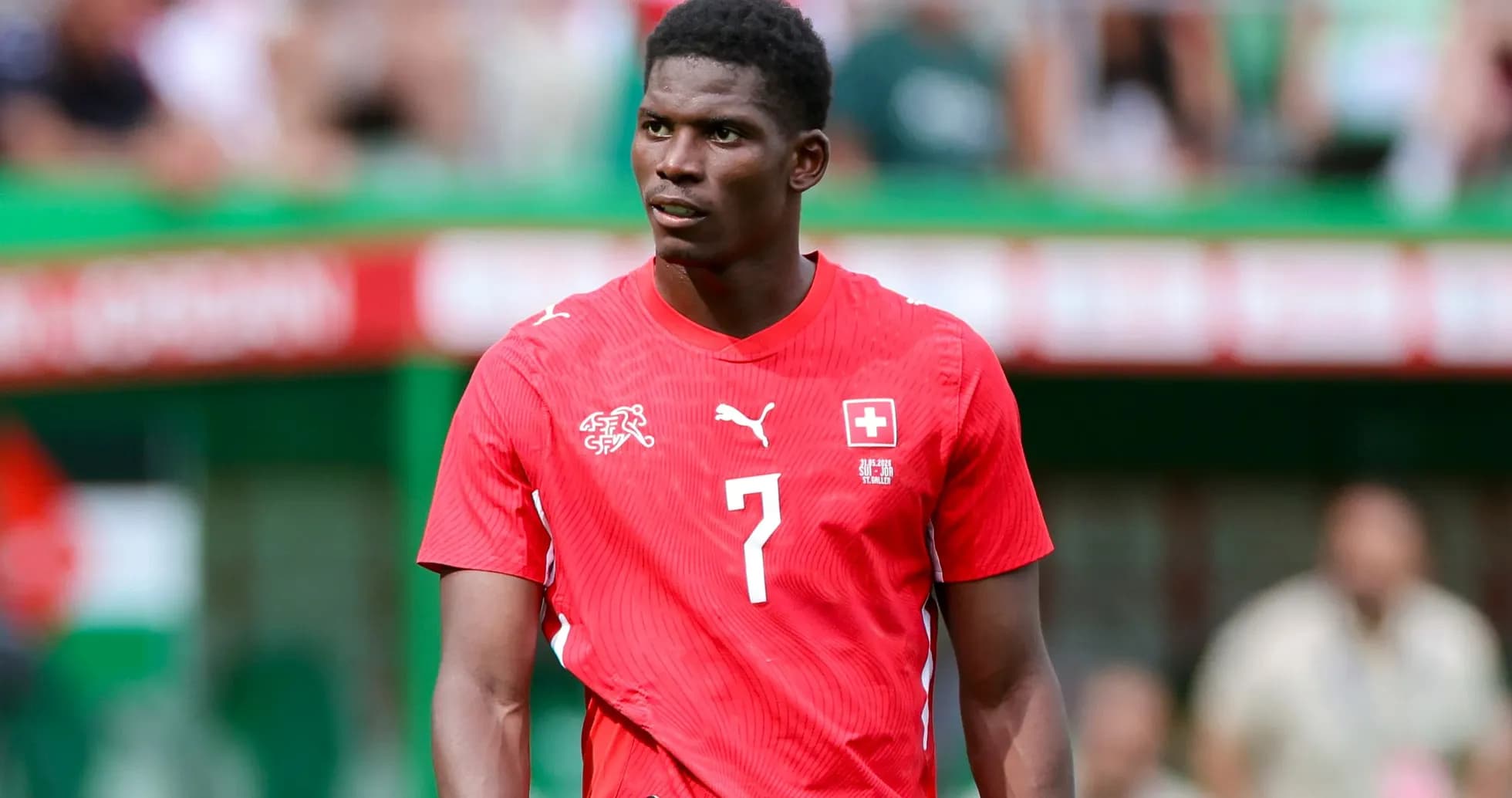 Player in red Swiss jersey on the field