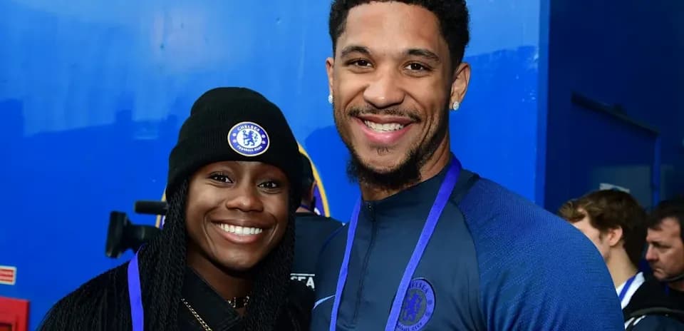 Two people smiling in Chelsea FC attire