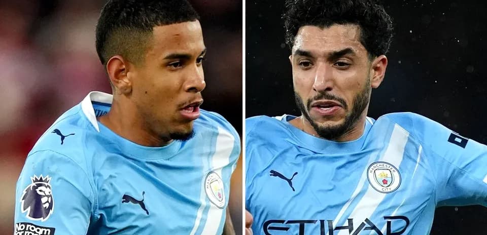 Two Manchester City players in light blue jerseys
