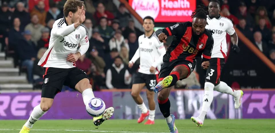 Fulham player challenging Bournemouth player for the ball