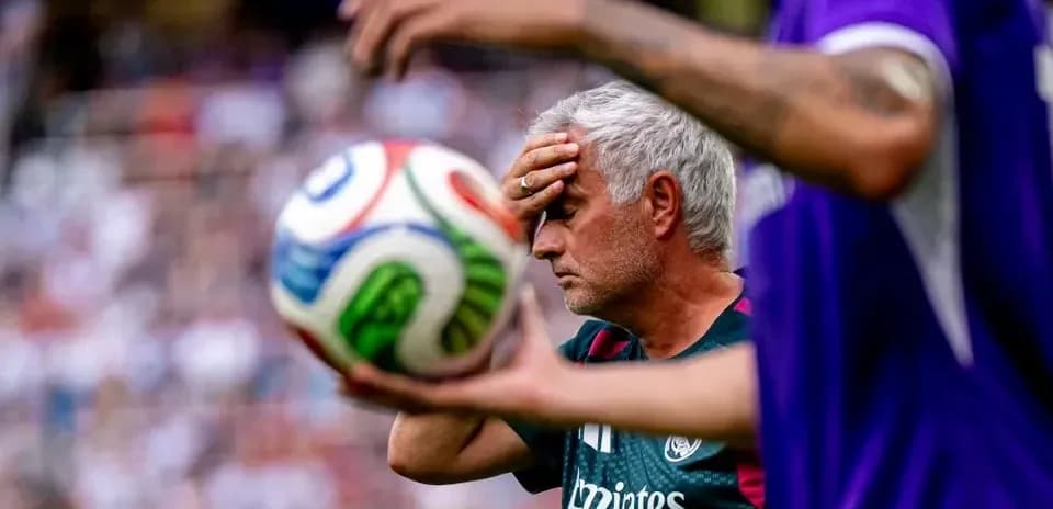 Coach with hand on forehead during match action