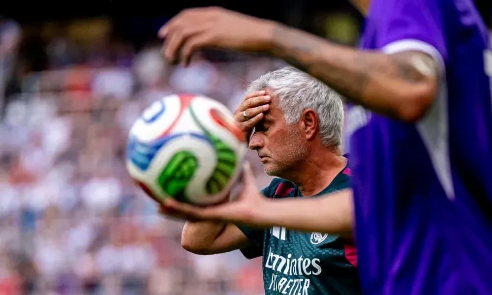 Coach with hand on forehead during match action