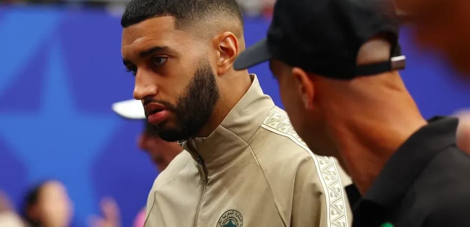Player in beige jacket talking before the match