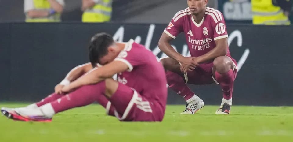 Real Madrid players sitting on the field after match