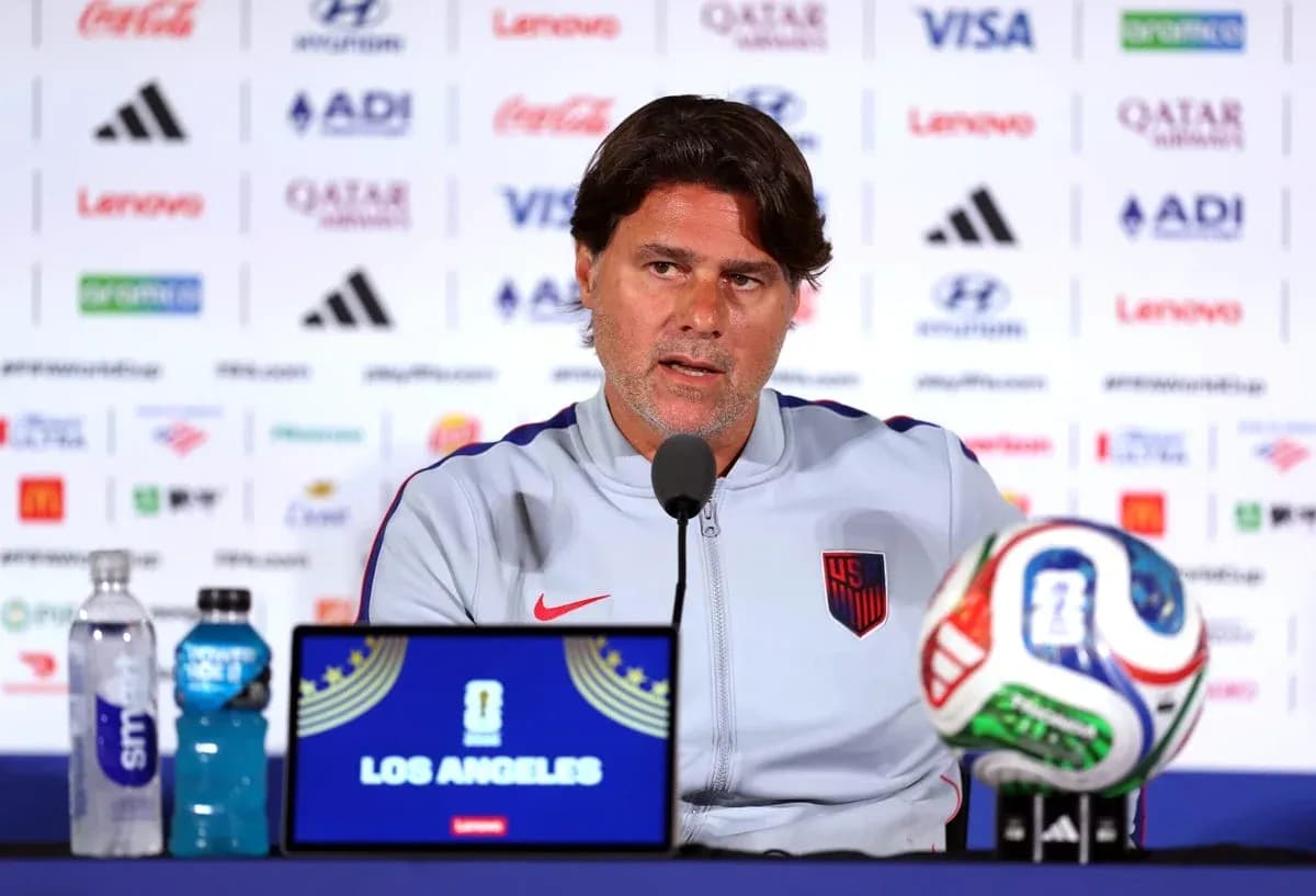 Coach speaking at press conference with soccer ball