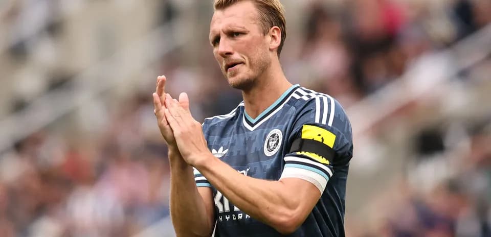 Player clapping and wearing captain's armband
