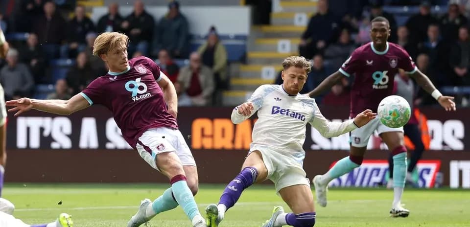 Burnley player challenging Aston Villa opponent