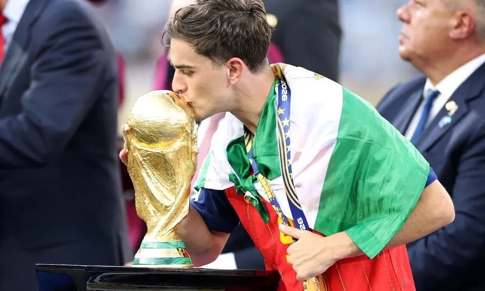 Player kissing World Cup trophy while wrapped in flag