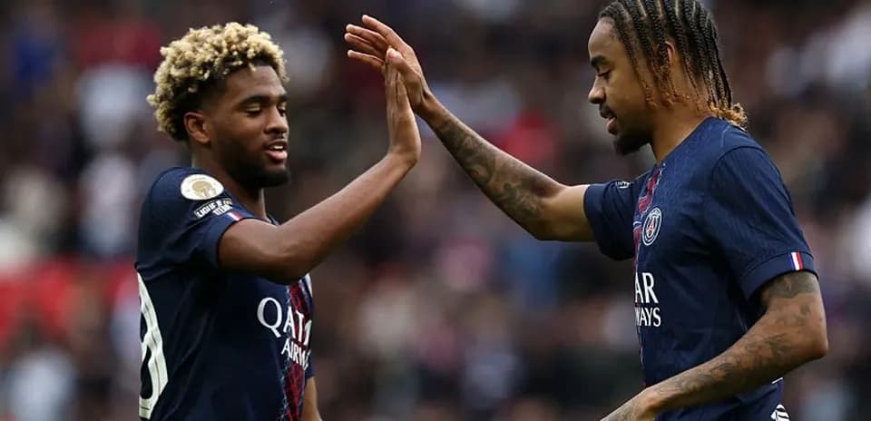 Two PSG players exchanging high-fives on the pitch