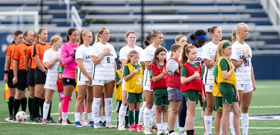UConn women's soccer team and youth players during anthem