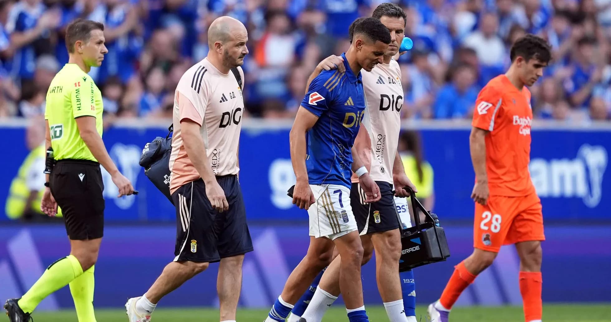 Oviedo player assisted off the field by staff