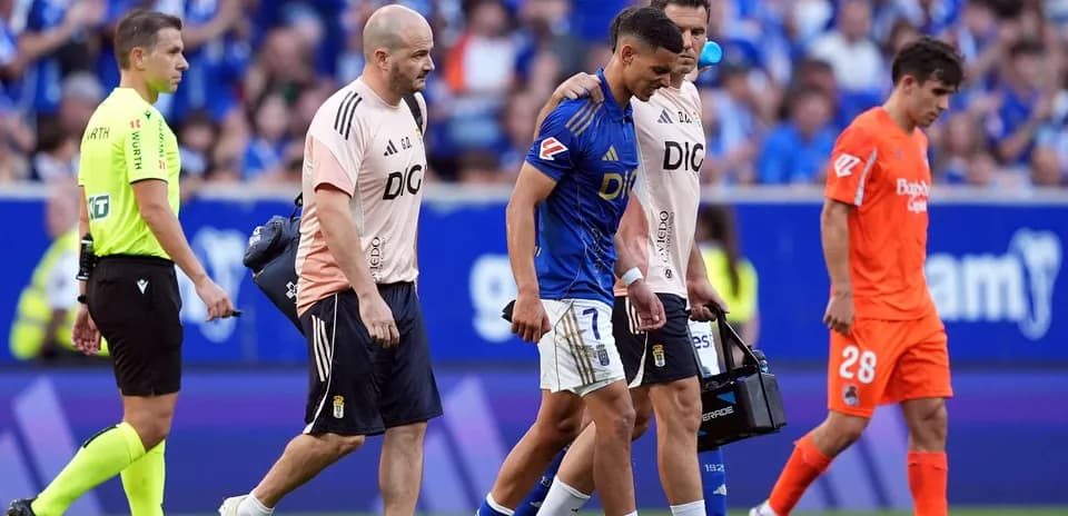 Oviedo player assisted off the field by staff