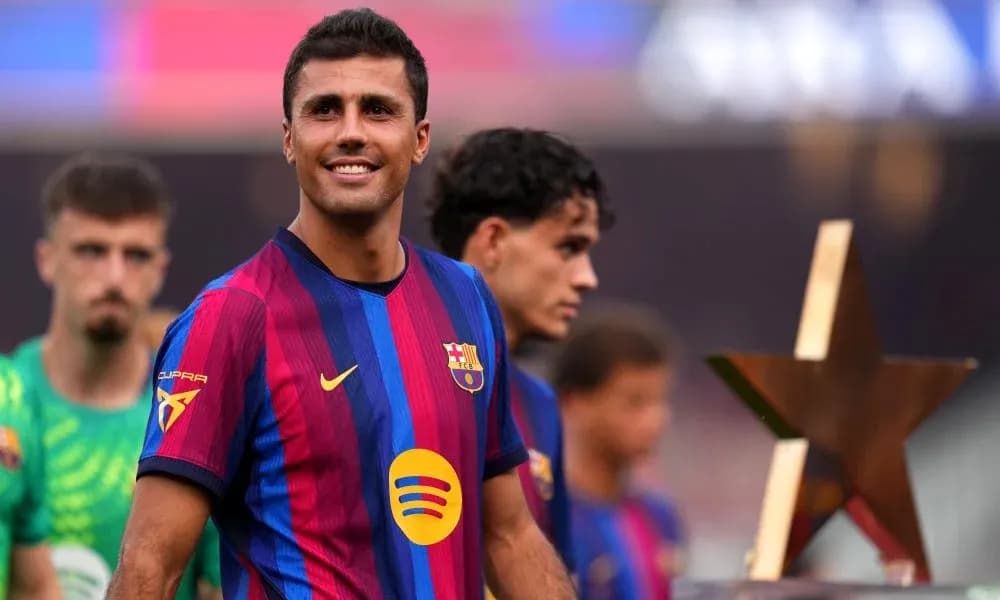 Player smiling while holding a trophy on field