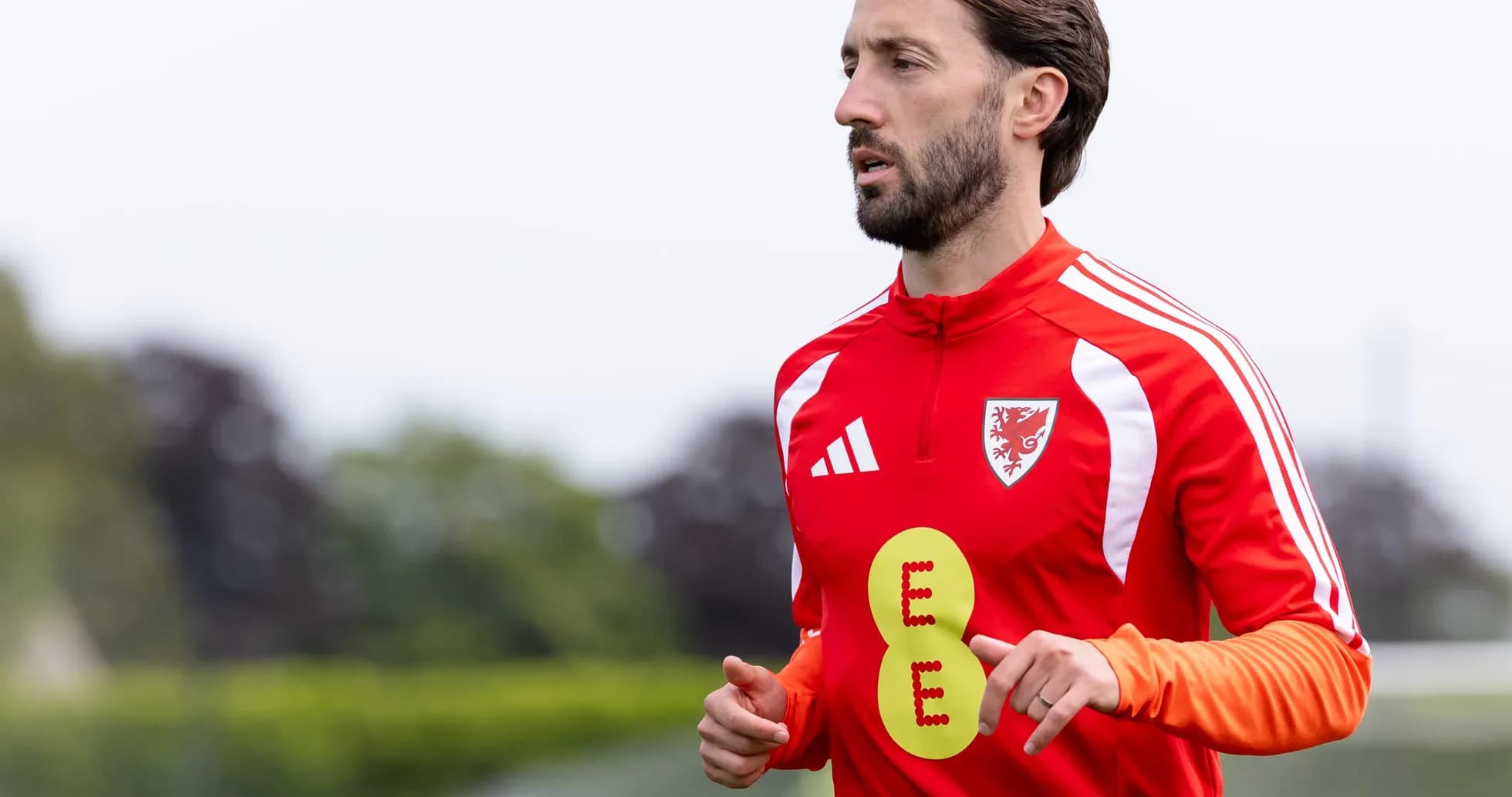 Player jogging in red training kit during practice