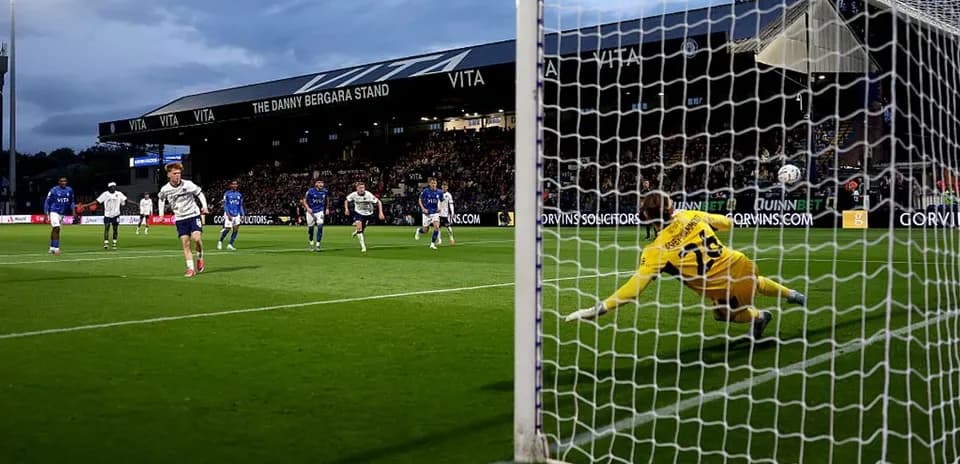 Player taking penalty kick while goalkeeper dives