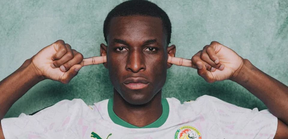 Player covering ears in Senegal national team jersey