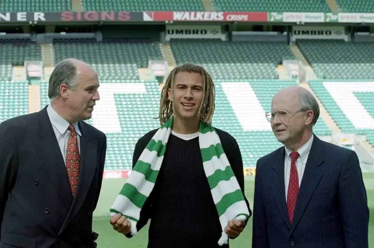Player holding scarf with club officials at stadium
