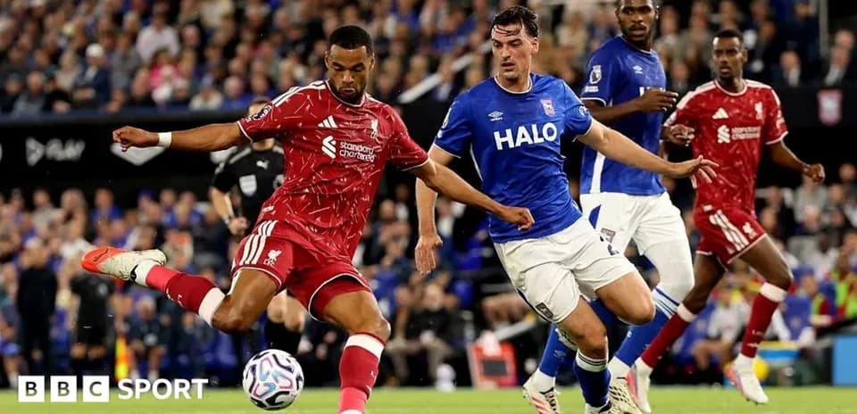 Liverpool player kicking the ball against Ipswich defender