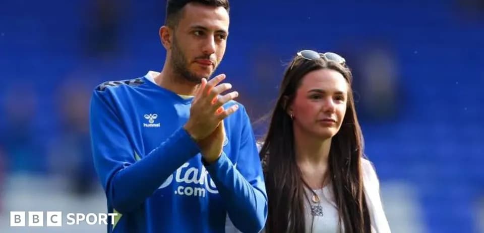 Player and companion walking on the pitch post-match