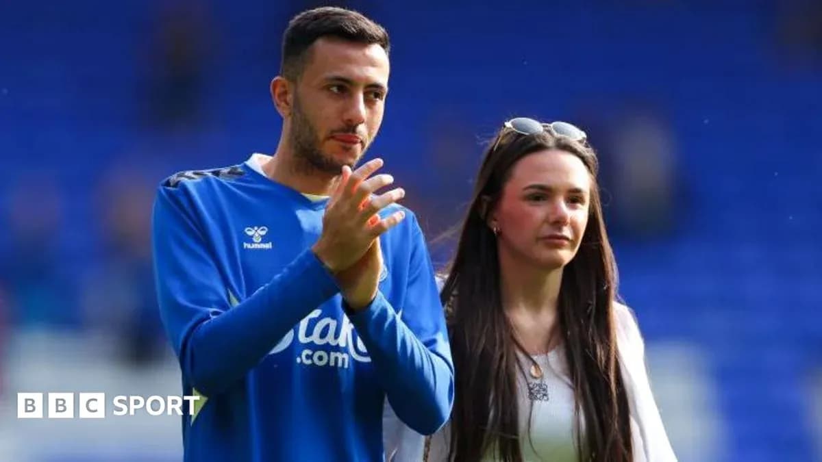 Player and companion walking on the pitch post-match