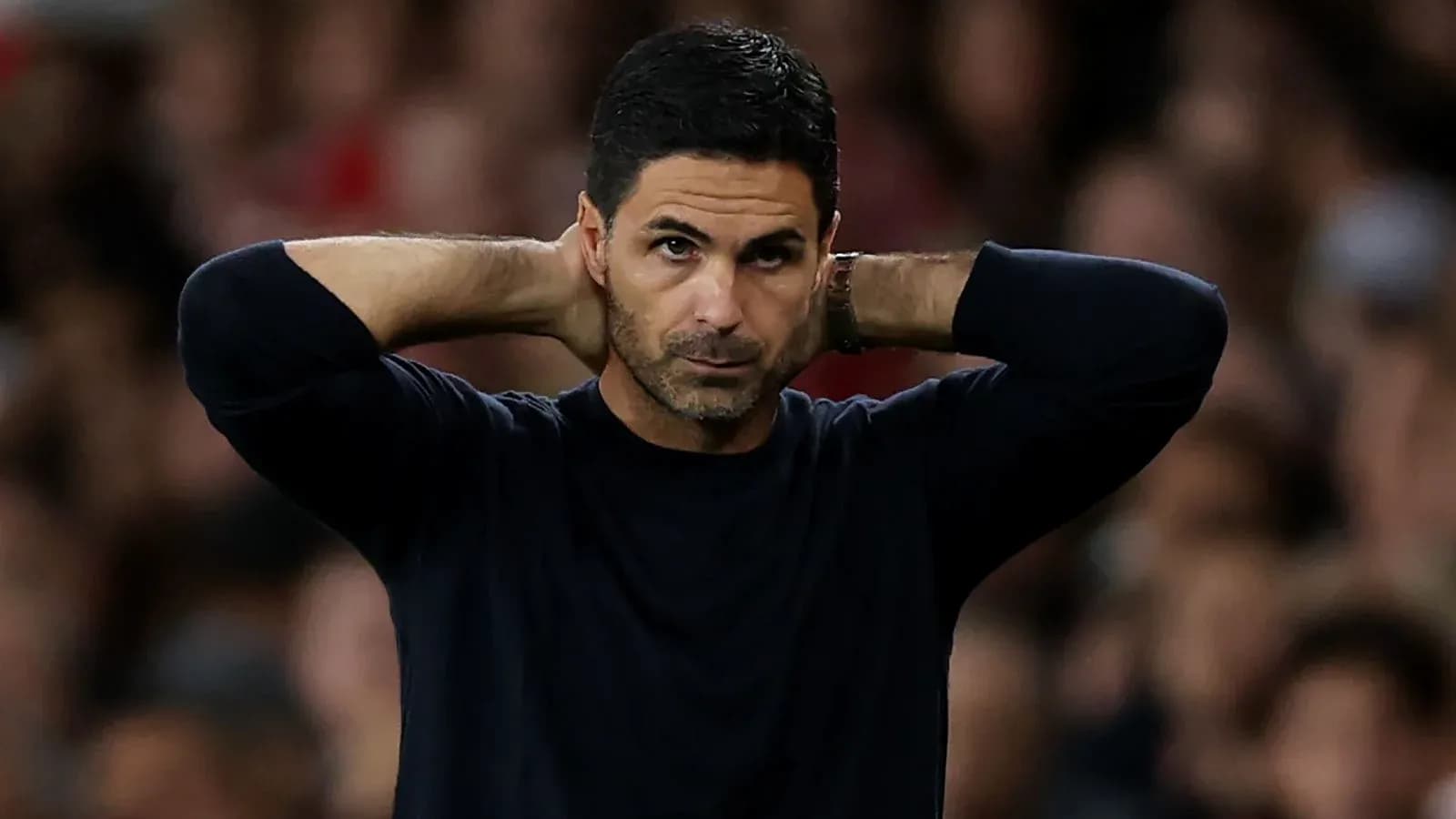 Manager with hands behind head during match