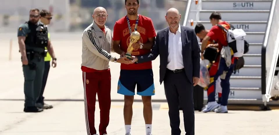 Players and officials celebrating World Cup victory at airport