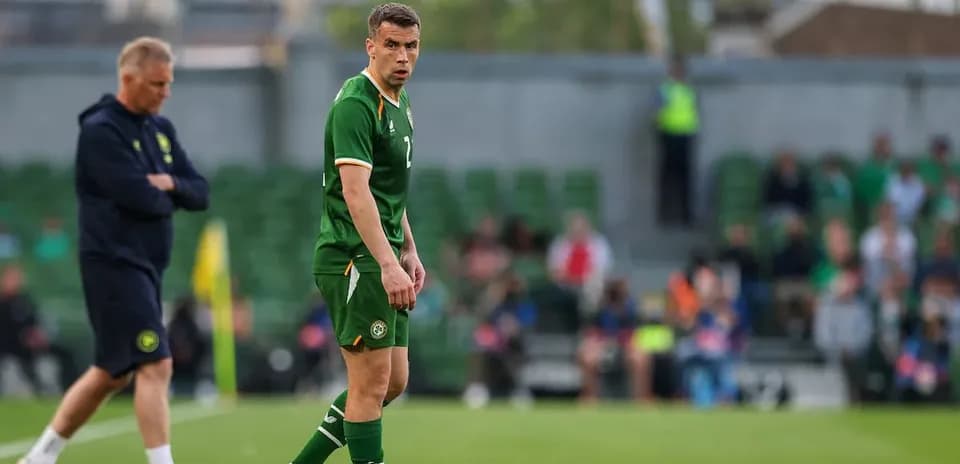 Ireland player on field with coach in background