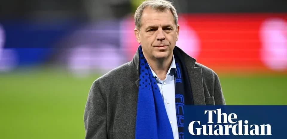 Man in coat and scarf at stadium event