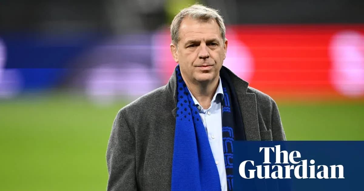 Man in coat and scarf at stadium event