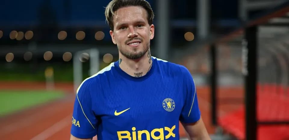 Player in blue Chelsea kit smiling on pitch