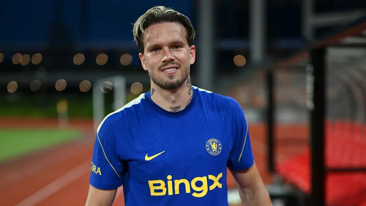 Player in blue Chelsea kit smiling on pitch