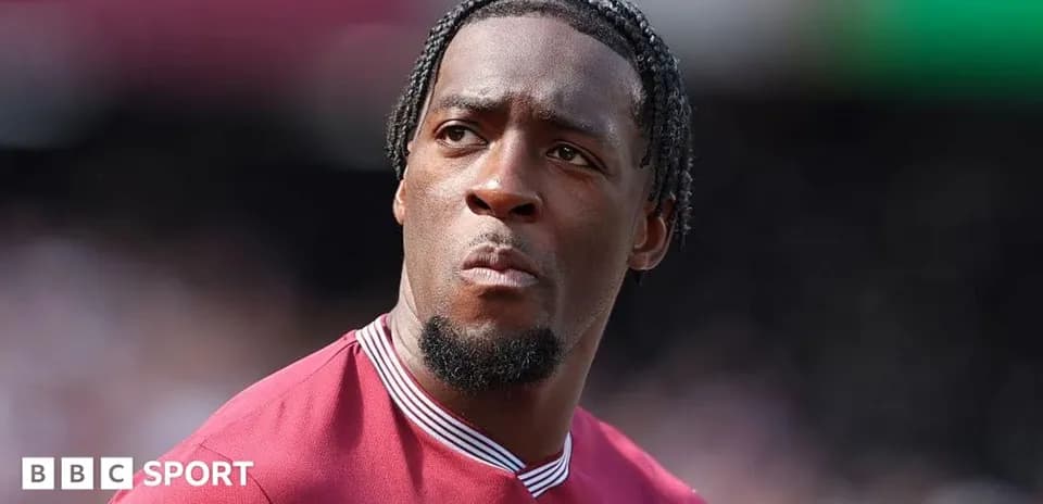 Player in maroon jersey looking focused on field