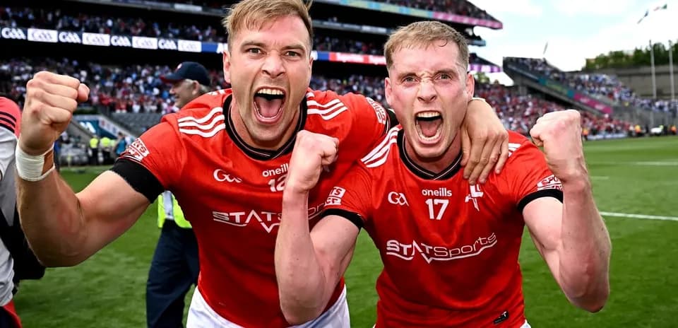 Two players celebrating in red jerseys after victory